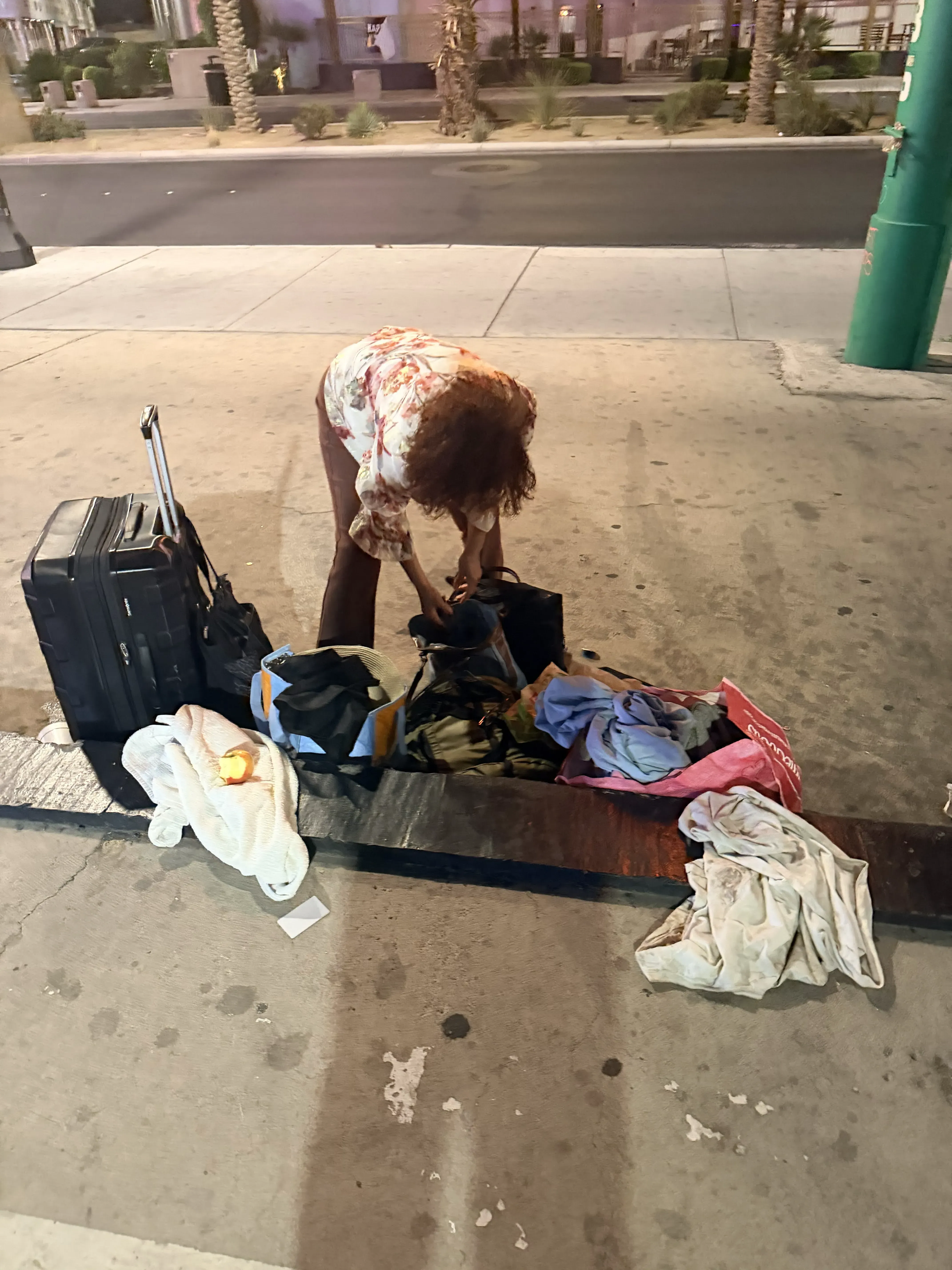 Gloria with her bags on the sidewalk